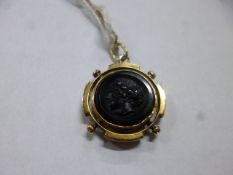 A CORNELIAN CARVED INTAGLIO PENDANT, measuring approximately 20mm in diameter, together with a
