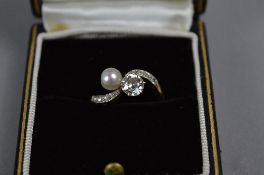 AN EARLY 20TH CENTURY DIAMOND AND CULTURED PEARL CROSSOVER DESIGN RING, to diamond set engraved