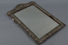 A LATE VICTORIAN SILVER MOUNTED SHAPED RECTANGULAR EASEL BACKED DRESSING TABLE MIRROR, ornate