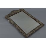 A LATE VICTORIAN SILVER MOUNTED SHAPED RECTANGULAR EASEL BACKED DRESSING TABLE MIRROR, ornate