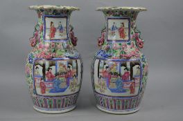A PAIR OF LATE 19TH CENTURY CHINESE CANTON FAMILLE ROSE TWIN HANDLED BALUSTER VASES, wavy rims,