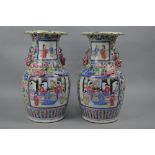 A PAIR OF LATE 19TH CENTURY CHINESE CANTON FAMILLE ROSE TWIN HANDLED BALUSTER VASES, wavy rims,