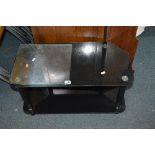 A BLACK GLASS TV STAND