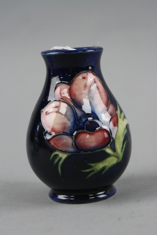 A SMALL MOORCROFT POTTERY VASE, 'Anemone' pattern on blue ground, impressed marks to base, height