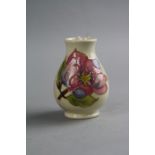 A SMALL MOORCROFT POTTERY VASE, 'Magnolia' pattern on cream ground, impressed marks to base, height