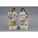 A PAIR OF STAFFORDSHIRE FIGURES, gentleman holding a flower with seated dog on plinth and lady