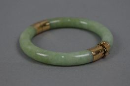 A MODERN JADE BANGLE, round hinged design with two pale green jadeite hooped sections, each capped