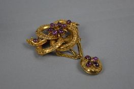A VICTORIAN AMETHYST SCROLL KNOT BROOCH, with an oval drop pendant and swag chains, hair compartment