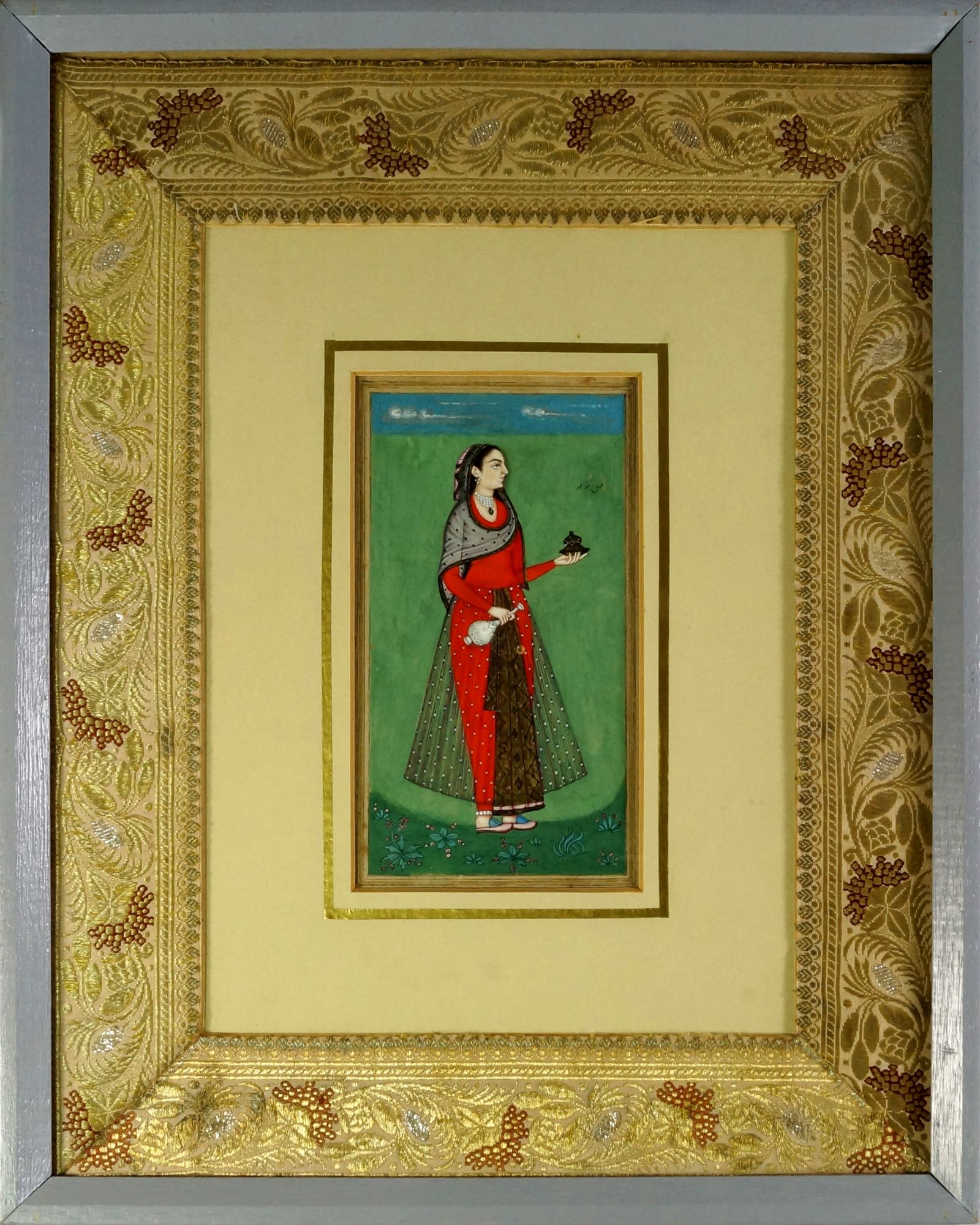 A Mughal lady, North India, 19th century, shown standing wearing red robes, within a floral border,