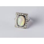 An opal and diamond ring, the cabochon opal approx 14mm x 9mm within a diamond set unmarked white