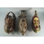 Two tribal masks, 20th century, one mounted with a pair of courting birds, the other with a bird
