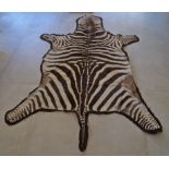 A vintage felt-backed zebra skin rug, 259x153cm,