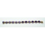 A 9ct gold bracelet claw mounted with twelve oval cut amethysts, each stone 10mm x 8mm,