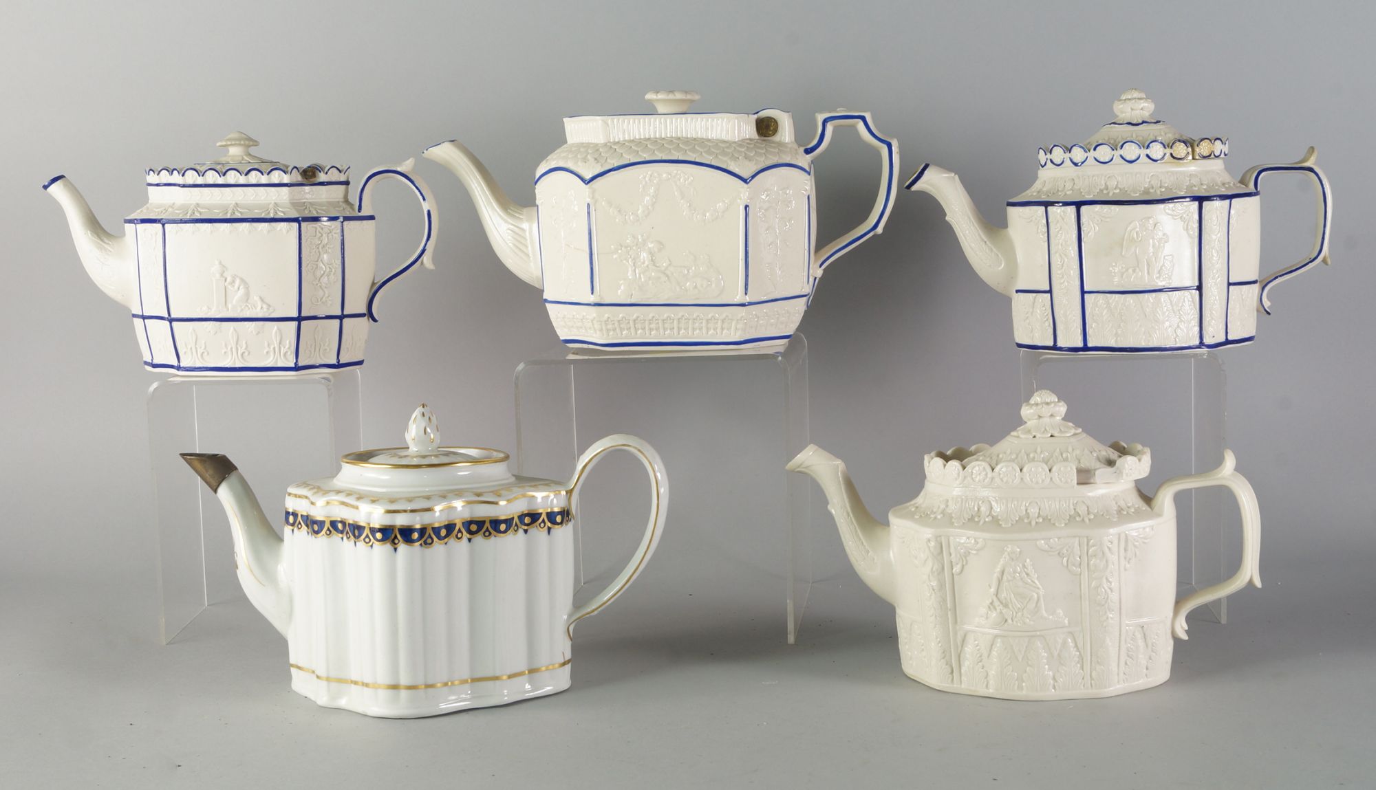 Four Parian porcelain tea pots, early 19th century, three of which highlighted in blue enamel work,