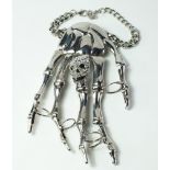 Butler & Wilson, a novelty anodized metal skeletal hand cuff, with applied marcasite set skull,