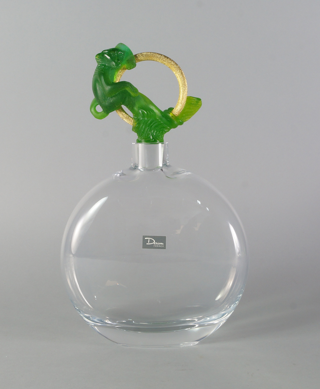 Daum, a glass decanter with a stopper of gilt ring form moulded with a green pate-de verre monkey,