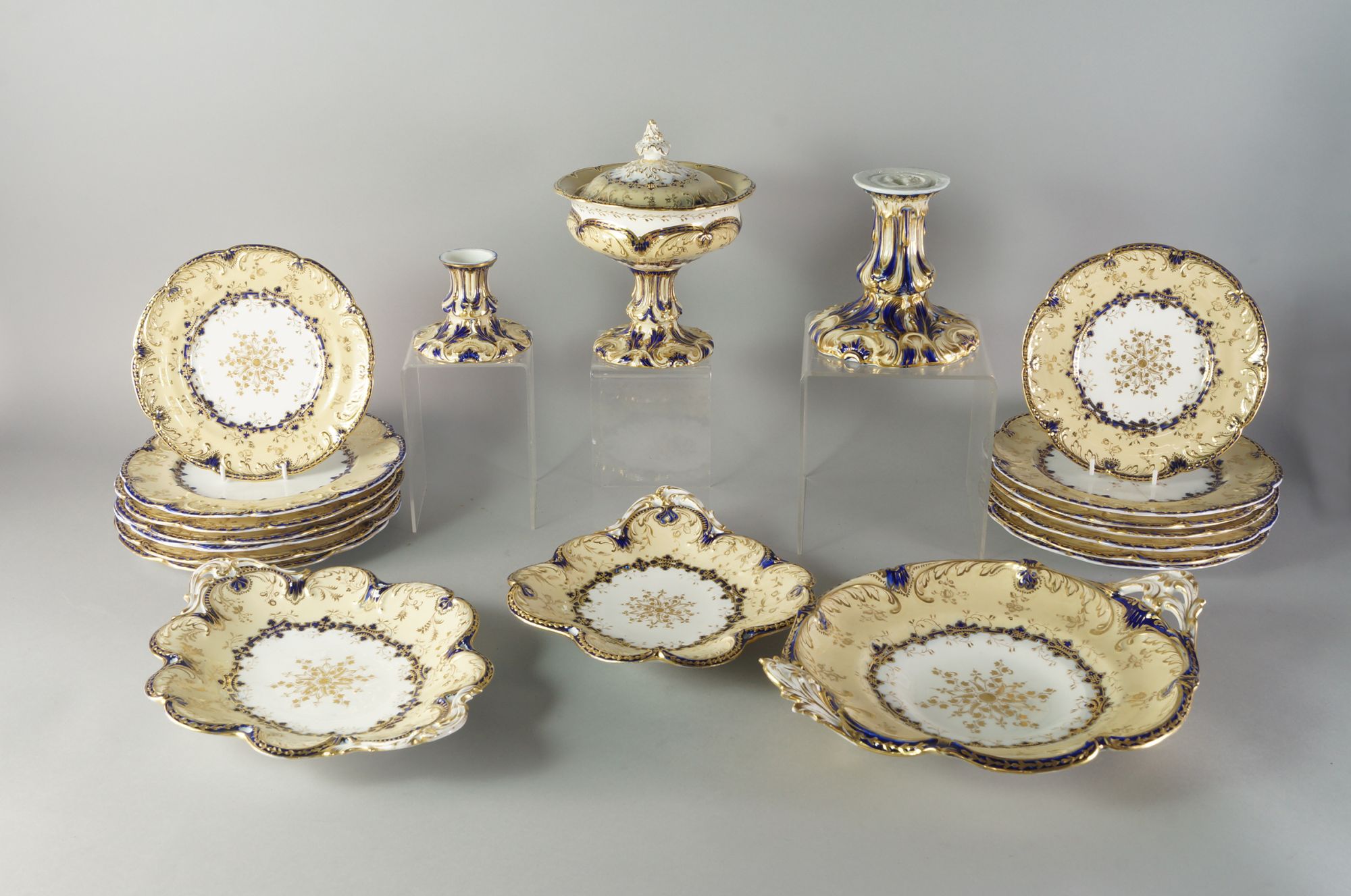 An English porcelain part dessert and dinner service, 19th century, with cream and blue borders,