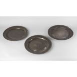 A set of four pewter chargers, 18th century, with plain reeded rims, all bearing faint touch marks,