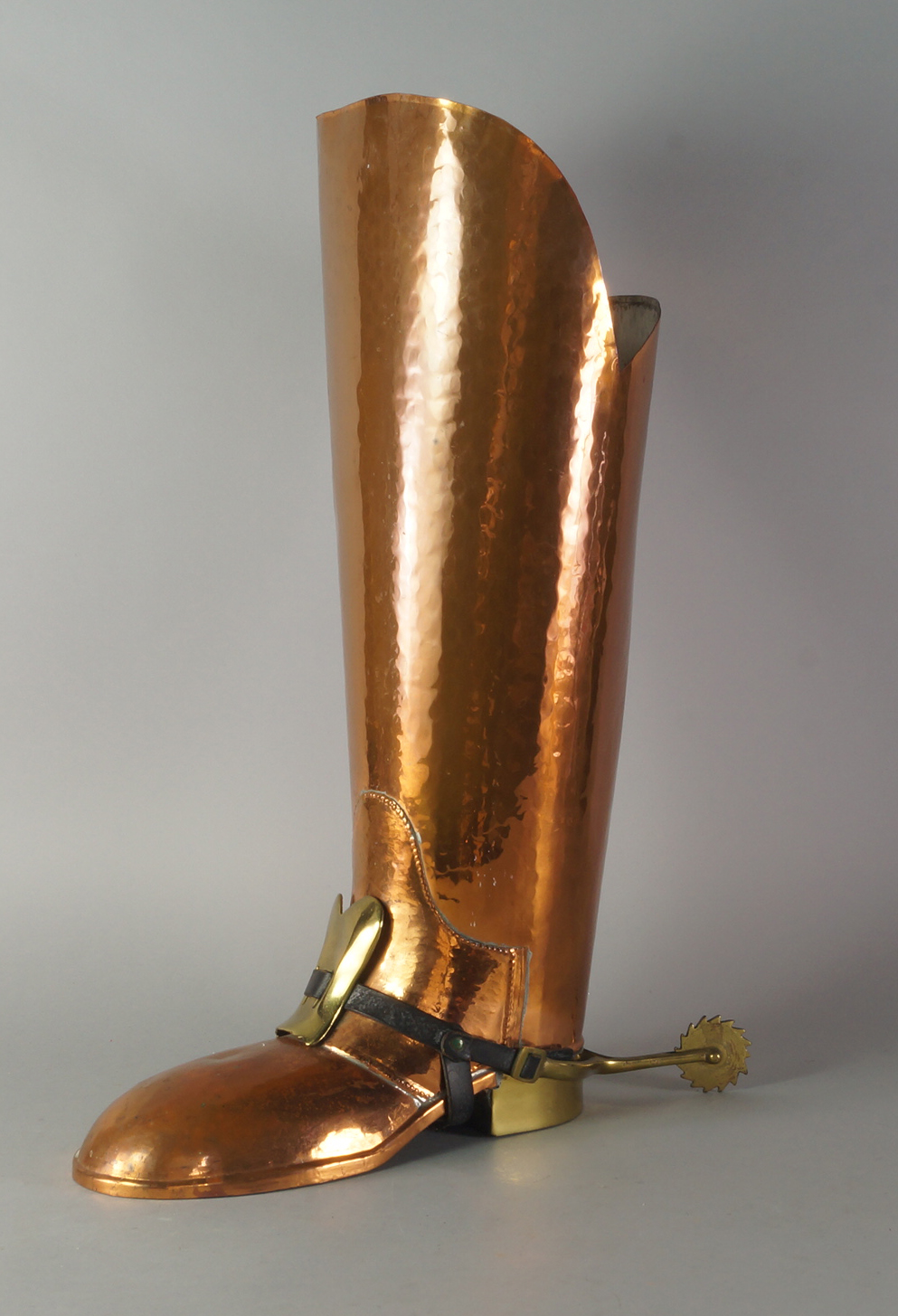 A copper and brass umbrella stand, 20th century, in the form of a postilion's boot,