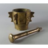A bronze mortar and pestle, 19th century, the mortar of cylindrical form with six shaped lugs,