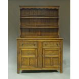 An oak dresser, 20th century, the plate rack with shelves on rectangular base,