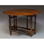 A walnut gate leg table, 20th century, on turned legs joined by long stretchers, with bun feet,