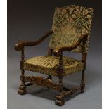A carved walnut 17th century style arm chair with carved acanthus arms and floral upholstery