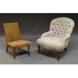 A Victorian button upholstered tub chair on mahogany baluster front legs with brass casters and a