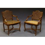 A pair of French carved beech wood armchairs, 19th century, with caned backs and seats,