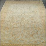 An Indian carpet with all over foliate design, in a pale blue field with straw coloured border,