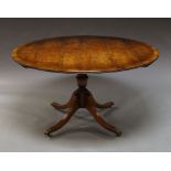 A George III style yew wood and mahogany circular dining table, turned column on swept feet,