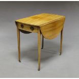 A George III mahogany table, with oval twin flap top above frieze drawer, on square tapering legs,