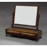 An early Victorian mahogany swing-frame dressing table mirror with ring turned uprights and two