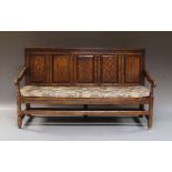 An oak settle, 19th century, with panelled back and seat, on square legs joined by stretchers,