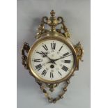 A brass wall clock, 20th century, the round case with Urn and foliate cresting,