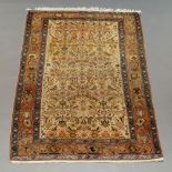 A West Persian rug with all over design in ivory field, brick red main border,