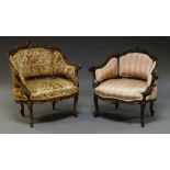 Two Victorian mahogany armchairs, in the French taste, each with florally carved frames,