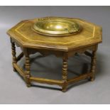A Middle Eastern octagonal hardwood table, 20th century, with central brass bowl on turned legs,