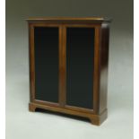 A mahogany dwarf bookcase, 20th century, with a pair of glazed doors, enclosing three shelves,