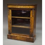 A Victorian walnut and gilt metal mounted pier cabinet, with glazed door enclosing shelves,
