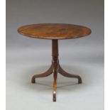 A Georgian mahogany circular tilt top table, with turned pedestal, on tripod legs,