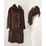 A full length mink coat, with leather covered buttons, by Cavendish House, Cheltenham,