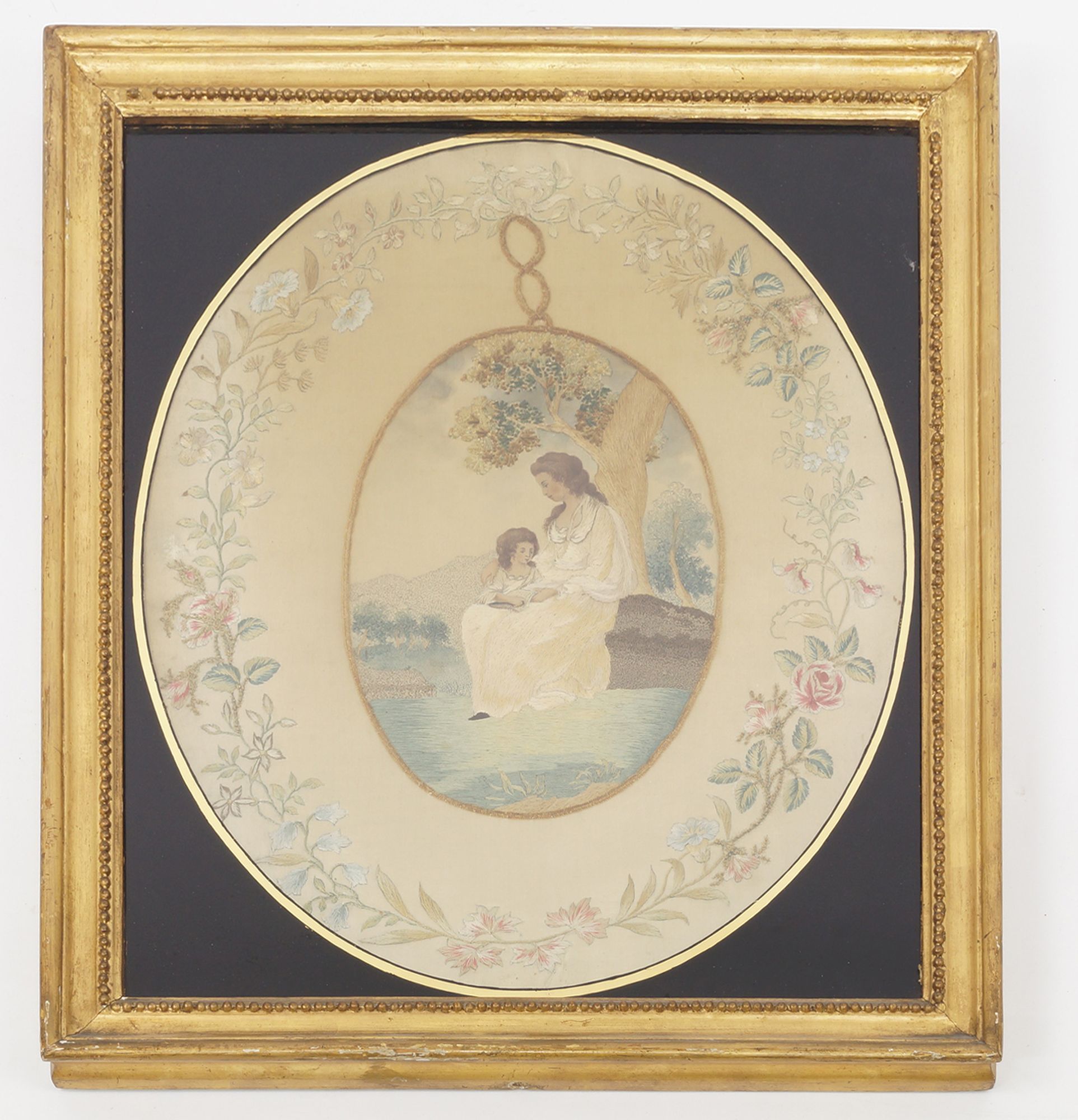 A Regency silkwork picture, depicting a mother and child,