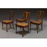 A set of four Edwardian mahogany and marquetry inlaid dining chairs with pierced central splat