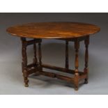 A walnut gate leg table, 20th century, on turned legs joined by long stretchers, with bun feet, 77cm