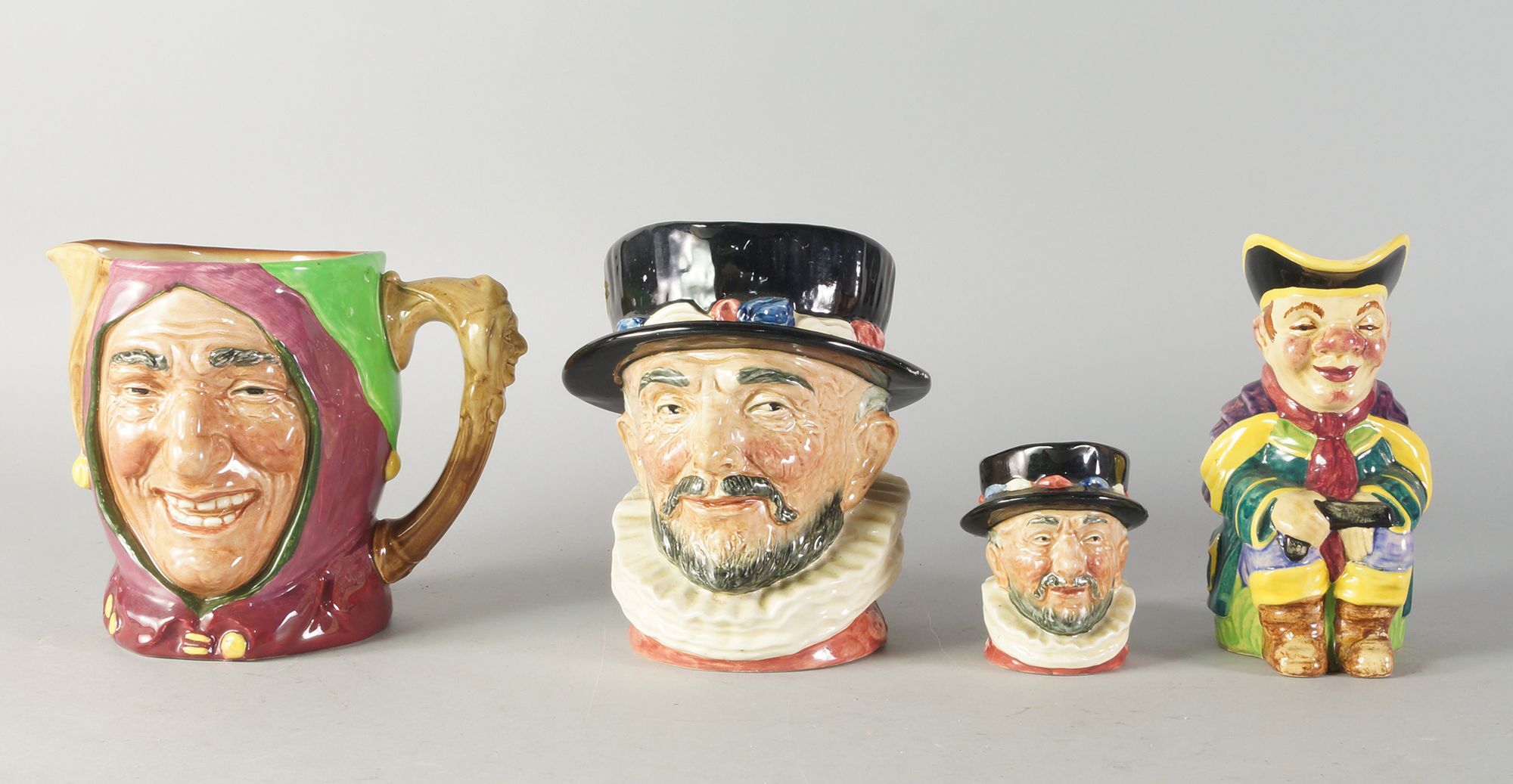 Royal Doulton, two toby jugs, the Beef eater and the Jester, together with a miniature Beef eater