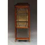 An Edwardian mahogany and inlaid display cabinet with single glazed door enclosing two shelves,