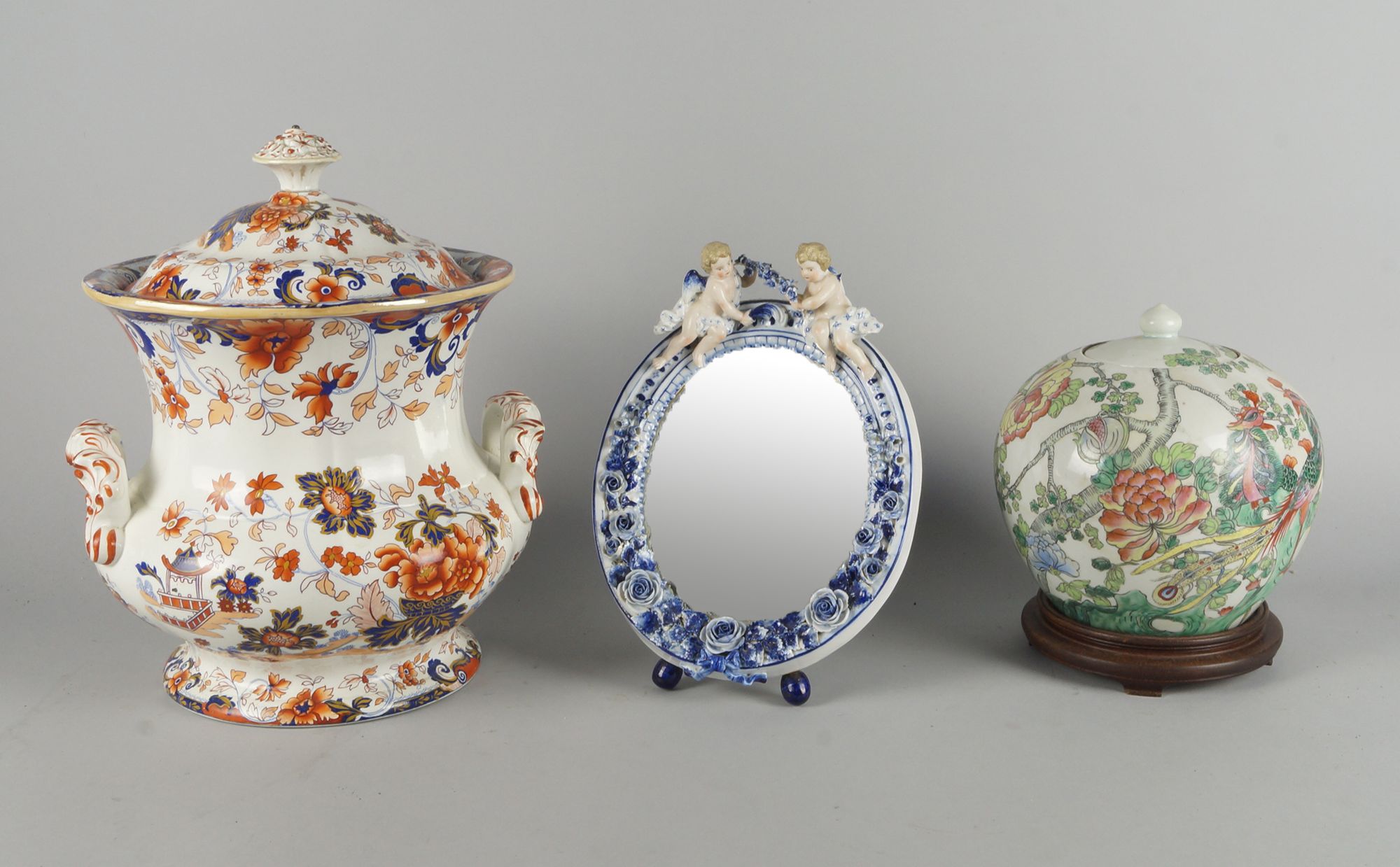 A German Dresden type porcelain mirror, late 19th century, with a cresting in the form of a pair
