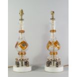 A pair of glass and coloured glass baluster lamp bases, 20th century, standing on brass Greek key