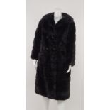 A black mink coat, c.1970s, rounded collar and lapels, double breasted with four large domed